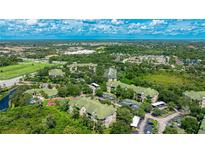 Expansive aerial view of a community with lush landscaping, green rooftops, and surrounding nature at 5168 Northridge Rd # 106, Sarasota, FL 34238