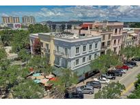 Charming building exterior with awnings, balconies, and well-manicured trees providing shade and an inviting atmosphere at 525 N Orange Ave # 202, Sarasota, FL 34236