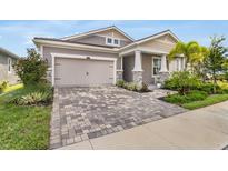 Charming single-Gathering home boasting a landscaped yard, a two-car garage, and a welcoming front porch at 5770 Long Shore Loop, Sarasota, FL 34238
