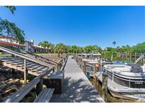 Community boat dock along the channel with boats parked on a sunny day at 709 Sorrento Inlt # 709, Nokomis, FL 34275