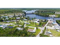Aerial view of neighborhood with home on grassy corner lot near waterway at 156 Myakka Rd, Venice, FL 34293