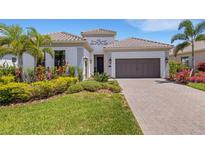 Charming home with lush landscaping, a two-car garage, and a beautifully paved driveway at 204 Corelli Dr, Nokomis, FL 34275