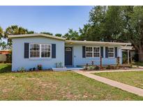 Charming light blue single-story home featuring mature landscaping and a walkway to the front door at 22275 Belinda Ave, Port Charlotte, FL 33952