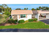 Charming home featuring stone accents, lush landscaping, and a well-maintained lawn at 2419 Riverbluff Pkwy # V233, Sarasota, FL 34231