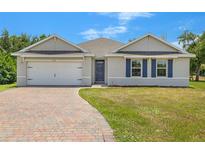 Charming single-story home with brick driveway, shutters, and attached two car garage at 27519 Pasto Dr, Punta Gorda, FL 33983