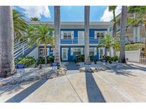 Charming blue two-story home with white trim, tropical landscaping, and reserved parking at 301 Highland Ave # 3, Bradenton Beach, FL 34217