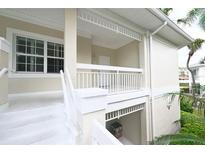 Exterior view of a two-story home with white railings and stairs, showcasing a charming architectural style at 3803 54Th W Dr # 201, Bradenton, FL 34210