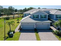 Charming two-story townhome featuring a two-car garage, neutral palette, and manicured lawn at 1017 Tidewater Shores Loop # 1017, Bradenton, FL 34208