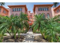 Charming condo building with lush tropical landscaping, secure gated entry, and classic architectural details at 1221 N Palm Ave # 303, Sarasota, FL 34236