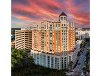 Beautiful high-rise building featuring tan brick, balconies, and a charming cupola, all under a vibrant sunset sky at 1350 Main St # 1703, Sarasota, FL 34236