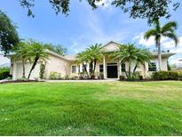 Charming single-story home featuring a well-manicured lawn, palm trees, and welcoming front entrance at 13809 18Th E Pl, Bradenton, FL 34212