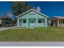 Charming bungalow with a covered front porch, updated siding, and a well-maintained lawn under a bright blue sky at 1420 E Frierson Ave, Tampa, FL 33603