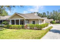 Well-maintained home with a screened-in porch and lush landscaping showcasing curb appeal at 1651 Red Oak Ln, Port Charlotte, FL 33948