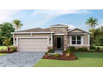 Charming single story home featuring stone accents, a two-car garage, and lush landscaping at 18225 Beach Ranch Ter, Lakewood Ranch, FL 34211