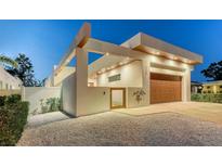 Stunning modern home showcasing a sleek design, a wood garage door, and manicured landscaping at 2135 Hyde Park St, Sarasota, FL 34239