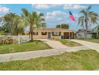 Charming home with tropical landscaping, a white picket fence, and an American flag waving in the breeze at 2715 36Th Avenue E Ter, Bradenton, FL 34208