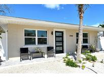 Charming home featuring a modern front door, neutral paint, well manicured landscaping and seating at 2908 Gulf Dr, Holmes Beach, FL 34217