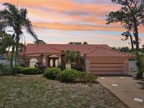 Charming single-story home featuring a red tile roof and lush landscaping at 321 Sorrento Dr, Osprey, FL 34229