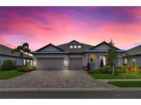 Charming single-story home with brick-paved driveway, well-manicured landscaping and attached three car garage at 3707 Wild Blossom Pl, Parrish, FL 34219