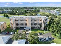 Expansive aerial view of the condo building, showcasing its landscaping, parking, and proximity to golf course at 4410 Fairways Blvd # 104, Bradenton, FL 34209