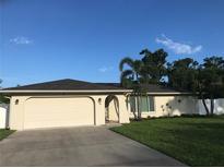 Charming single-story home with a two-car garage, arched entry, and mature palm tree at 48 Dade Ave, Sarasota, FL 34232