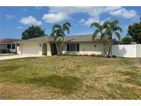 Charming single-story home featuring a well-maintained lawn, palm trees, and a two-car garage at 48 Dade Ave, Sarasota, FL 34232
