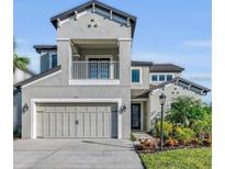 Beautiful two-story home with a gray exterior, two-car garage, small balcony, and nicely landscaped front yard at 8273 Shooting Star Rd, Sarasota, FL 34241