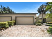 Home exterior with brick driveway leading to a spacious two-car garage with manicured landscaping at 8525 54Th Avenue E Cir, Bradenton, FL 34211