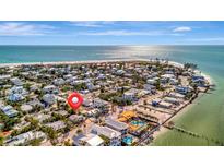 Stunning aerial view of a coastal community with beachfront homes and sparkling ocean views on a sunny day at 880 N Shore Dr, Anna Maria, FL 34216