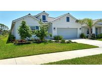 Charming one-story home boasts a well-manicured lawn, lush landscaping, and a neutral exterior color palette at 10186 Crystal Isle Cir, Sarasota, FL 34241