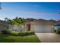 Charming single-story home with a well-manicured lawn, mature landscaping, and a two-car garage at 12642 Cara Cara Loop, Bradenton, FL 34212