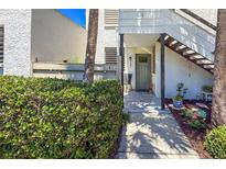 Inviting condo entrance with charming garden and brick pathway leading to a neutral-colored front door at 157 Pinehurst Dr # 157, Bradenton, FL 34210