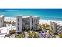 Stunning beachside condominium with pool, palm trees, and white sandy beach access at 230 Sands Point Rd # 3404, Longboat Key, FL 34228
