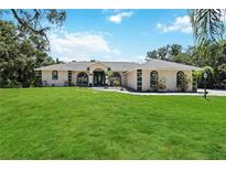 Charming single-story home with a lush green lawn and eye-catching architectural details at 296 Pine Ranch Trl, Osprey, FL 34229