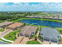 Beautiful aerial view of home with pond, lush landscaping and tile roof in a desirable community at 3027 Formia Ct, Lakewood Ranch, FL 34211