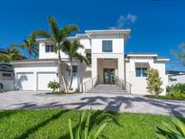 Stunning two-story home with a manicured lawn, mature palms and a paver driveway leading to a two car garage at 430 Pheasant Way, Sarasota, FL 34236