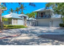 Stunning two-story home with a balcony, spacious garage and lush tropical landscaping at 4505 Camino Real, Sarasota, FL 34231