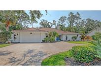 Beautiful home with a brick driveway, a white two-car garage door, and lush landscaping in front at 4665 Pine Harrier Dr, Sarasota, FL 34231