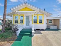 Charming home featuring a bright yellow accent, white siding, and a well-manicured green walkway at 55 Braden Castle Dr, Bradenton, FL 34208