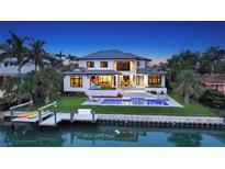 Stunning waterfront home featuring a private dock, sparkling pool, and lush landscaping at 612 Mourning Dove Dr, Sarasota, FL 34236