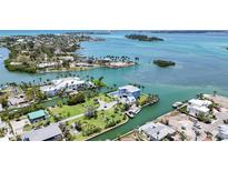 Stunning aerial view of coastal homes, showcasing turquoise waters and lush landscaping, perfect for waterfront living at 630 De Narvaez Dr, Longboat Key, FL 34228