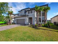 Beautiful two-story home featuring a manicured lawn, attached two-car garage, and lovely landscaping at 7533 Nighthawk Drive, Sarasota, FL 34241
