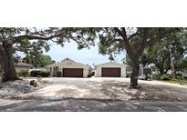 Charming single-story home featuring an expansive driveway and a 2-car garage with mature trees at 1016 Rhodes Ave, Sarasota, FL 34237