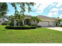 Charming single-story home featuring a manicured lawn, mature landscaping, and a three-car garage at 12358 Lavender Loop, Bradenton, FL 34212