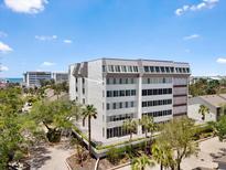 Beautiful building exterior with nice landscaping, palm trees, and a glimpse of a water view at 1255 E Peppertree Dr # 507, Sarasota, FL 34242