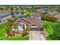 Stunning lakefront home with lush landscaping, a paver driveway, and a spacious three-car garage at 12644 20Th E St, Parrish, FL 34219