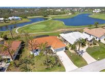 Beautiful aerial view of a home with an orange roof, with golf course and lake nearby at 16 Leeward Dr, Placida, FL 33946