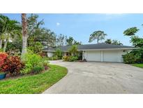 Sprawling home exterior featuring lush landscaping, a long driveway, and a two car garage at 1610 S Orange Ave, Sarasota, FL 34239