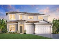 Elegant two-story home featuring a two-car garage, lush lawn, and inviting front entrance at 17723 Palmiste Dr, Bradenton, FL 34202