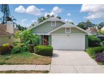 Charming one-story home with a well-manicured lawn, lush landscaping, and a two-car garage at 1869 Springbush Ln, Clearwater, FL 33763